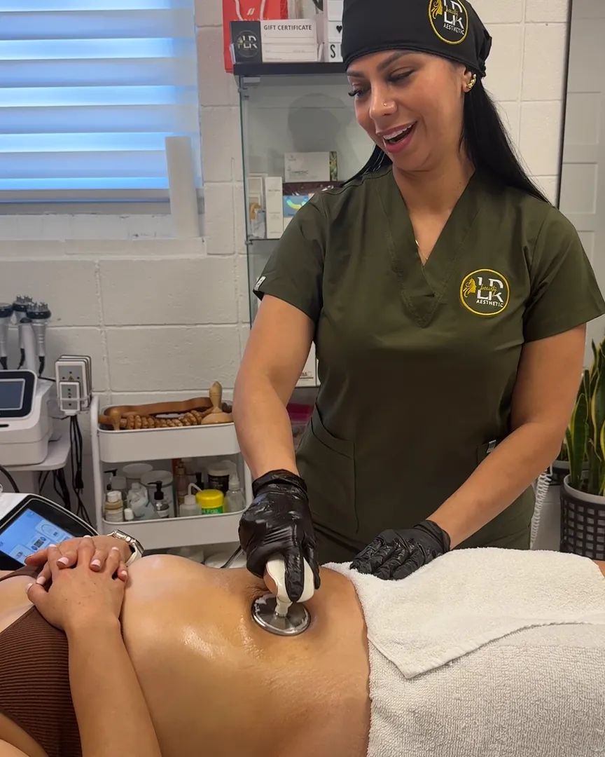 Leidy aplica aparatología corporal en el abdomen de una clienta