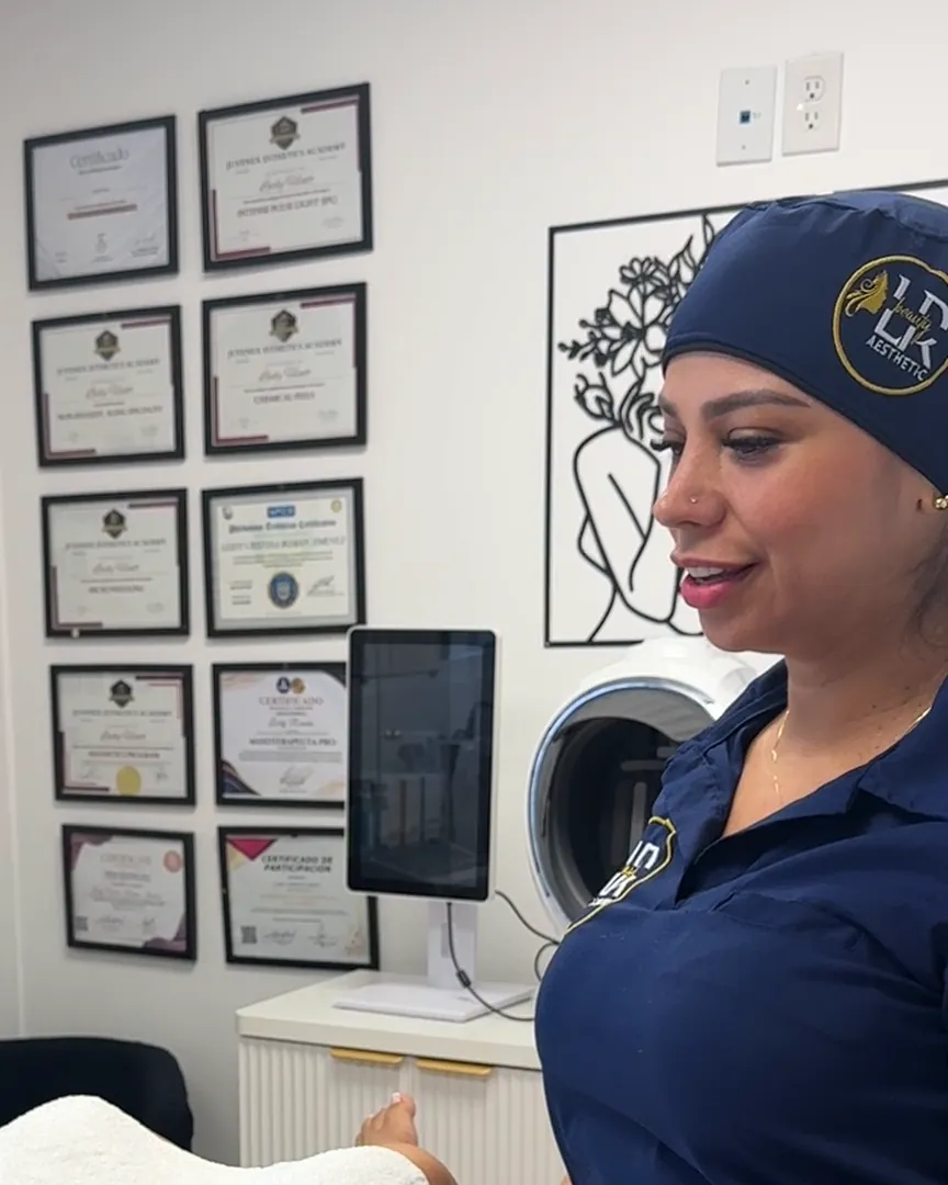 Leidy durante un tratamiento corporal, con sus certificados detrás